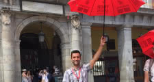 guía sujetando el paraguas rojo de sandemans en el punto de encuentro de la plaza mayor